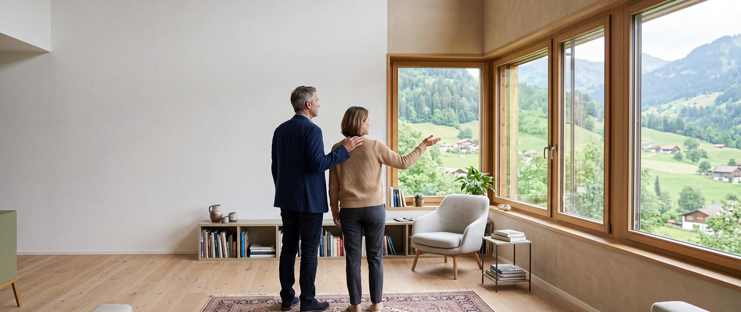 Zwei Personen in einem hellen Wohnzimmer blicken durch ein Panoramafenster ins Grüne
